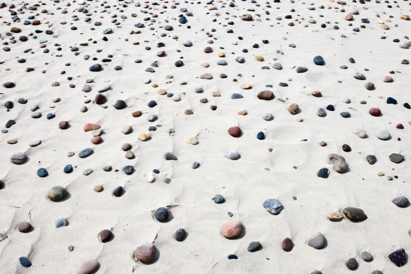 white sand beach with small colorful stones